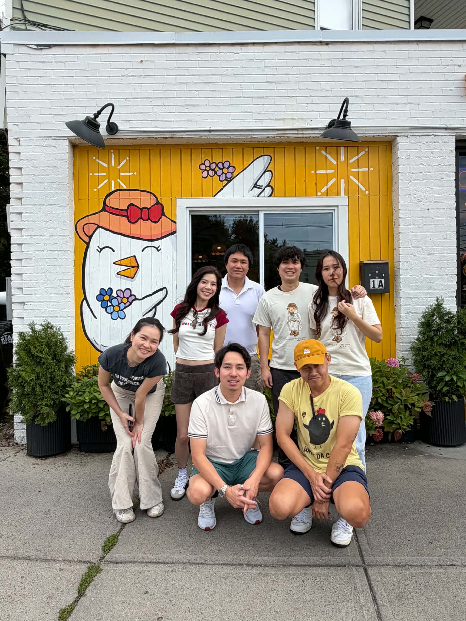 What Da Chick team smiling in front of the mural